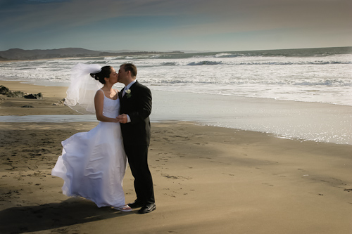 Half Moon Bay wedding - bride and groom kissing on the beach