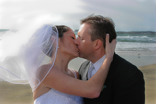 Half Moon Bay wedding - bride and groom kissing on the beach