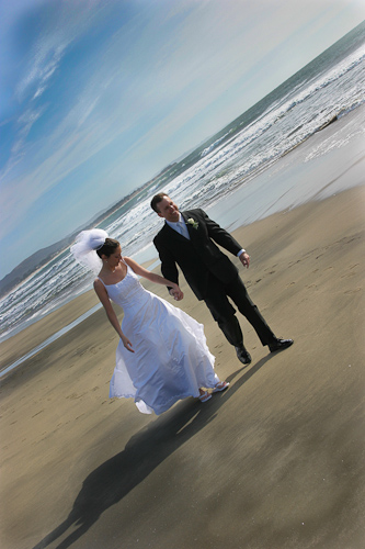 Half Moon Bay wedding - bride and groom walking on the beach